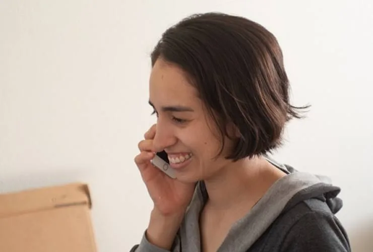 A woman smiling and talking on a phone
