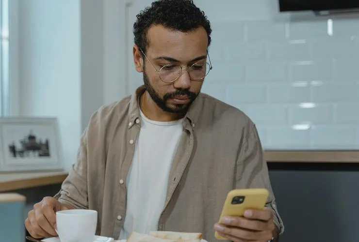 Close up shot of man looking down at this phone