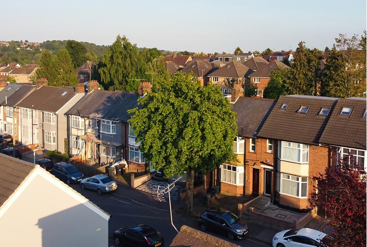 A street view featuring several cars parked along the side of the road.